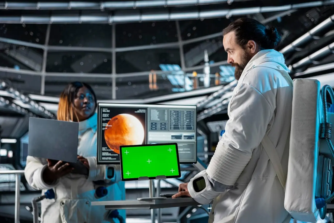 Исследователи космической станции анализируют планетарные данные о Марсе с помощью макета планшета.