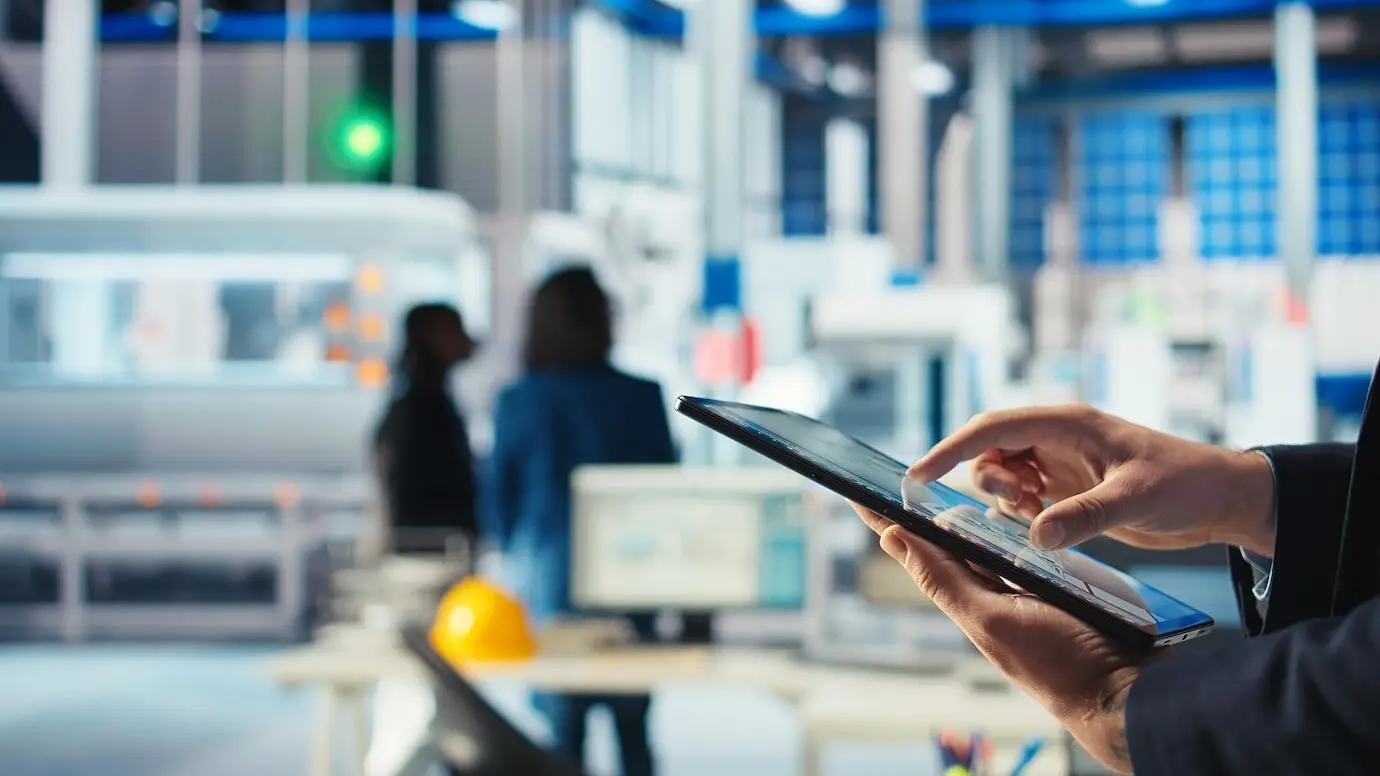 Сотрудник фотовольтаического завода использует на планшете программное обеспечение для отслеживания, чтобы диагностировать систему.